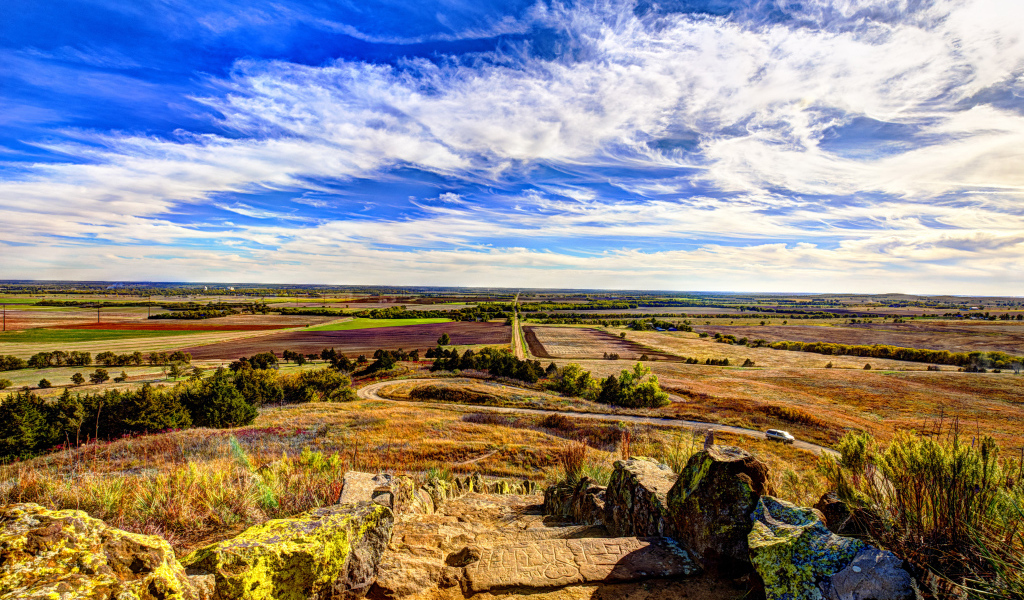 Вид на поле под красивым голубым небом с белыми облаками