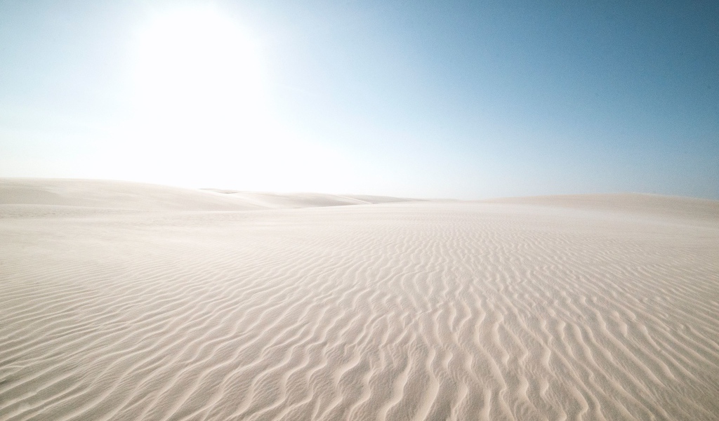Белый песок в пустыне на фоне голубого неба
