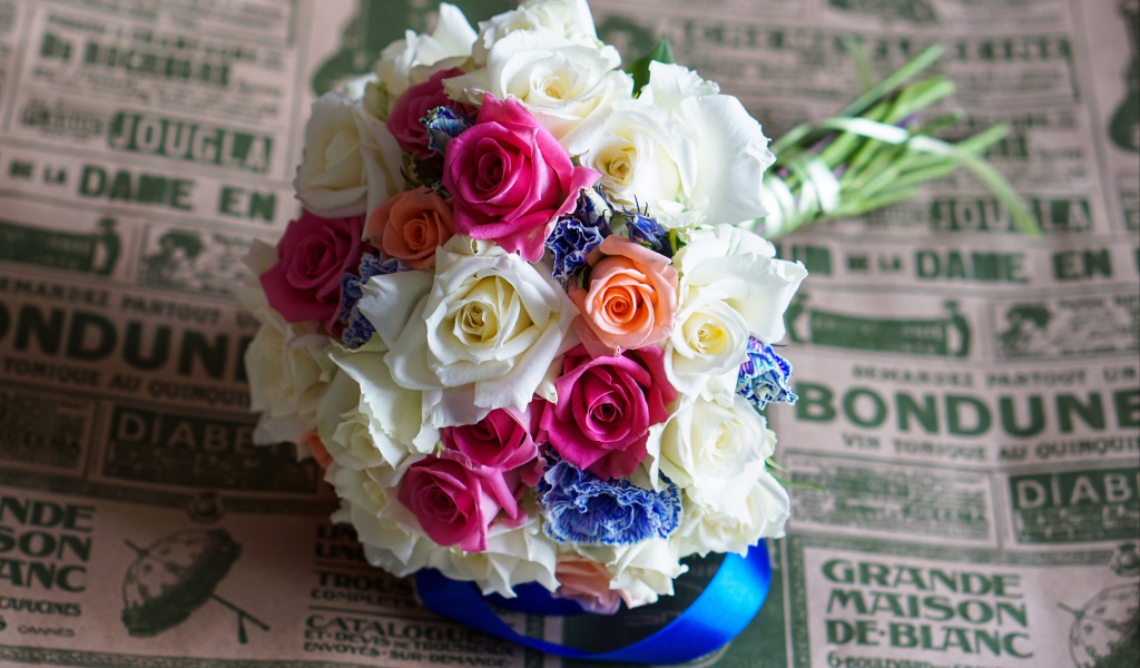 Красивый свадебный букет из роз лежит на газете