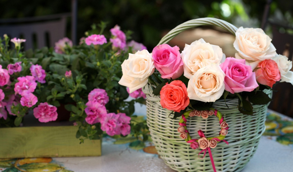 Букет нежных роз в корзине на столе с цветами
