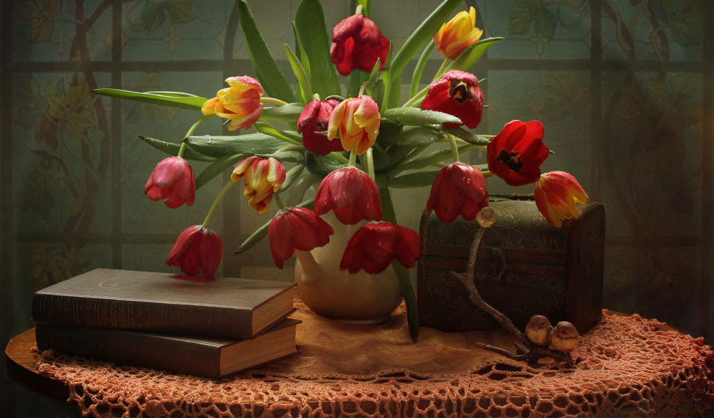 Букет тюльпанов на столе с книгами и шкатулкой