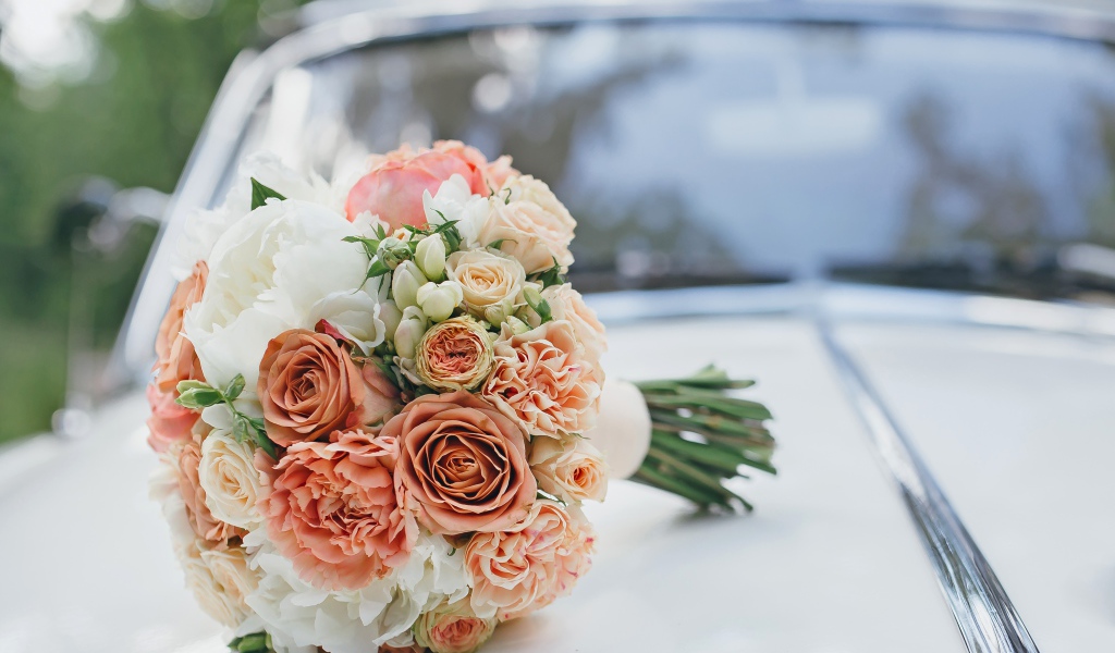 Свадебный букет роз лежит на машине
