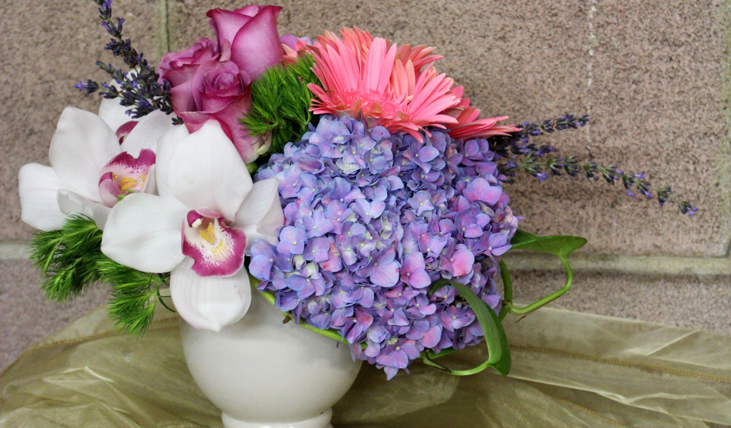 Красивый букет в белой вазе на фоне стены 