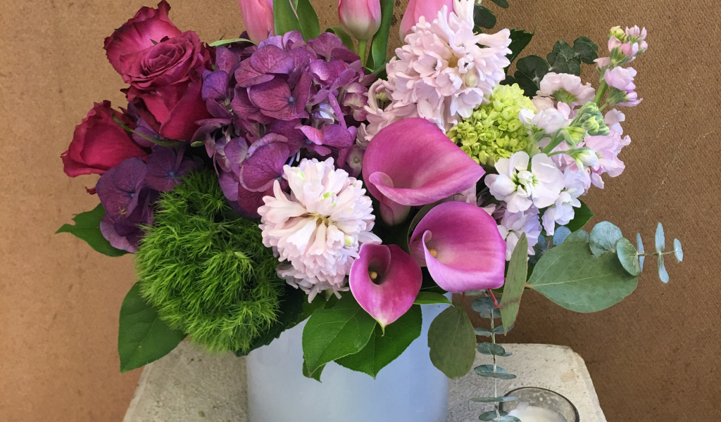 Красивый букет цветов в вазе у стены