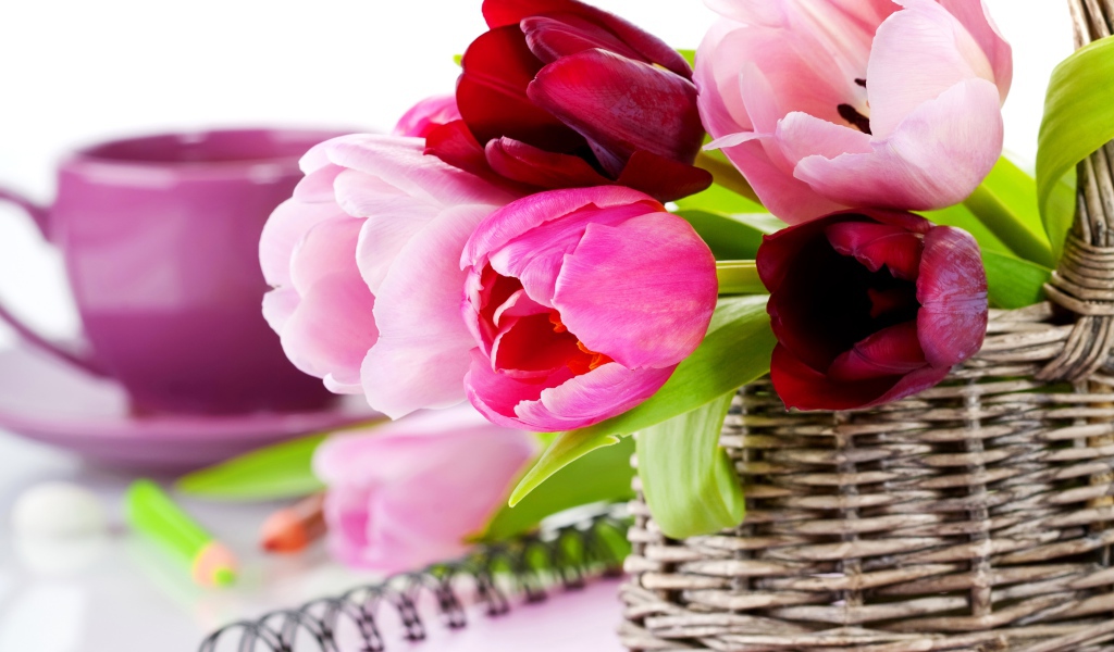 Букет разноцветных тюльпанов в корзине на столе с блокнотом