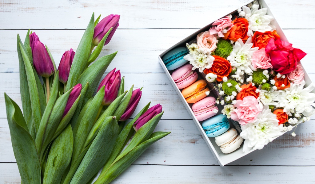 Букет сиреневых тюльпанов на столе с коробкой с макарунами