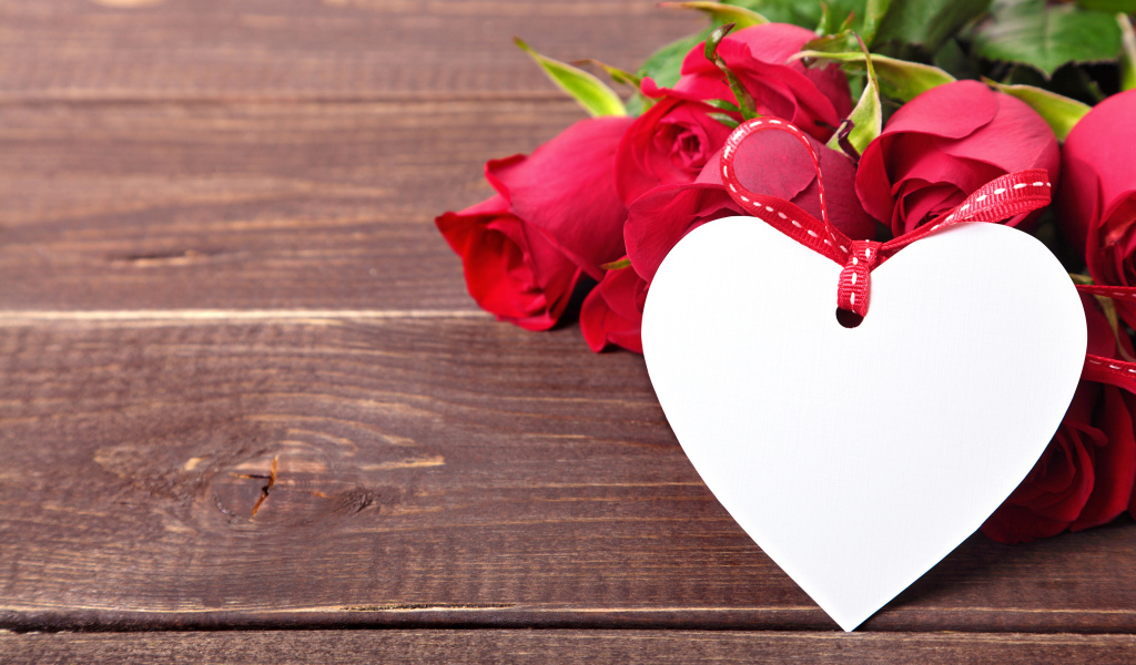 Букет розовых роз с бумажным сердцем на деревянном фоне