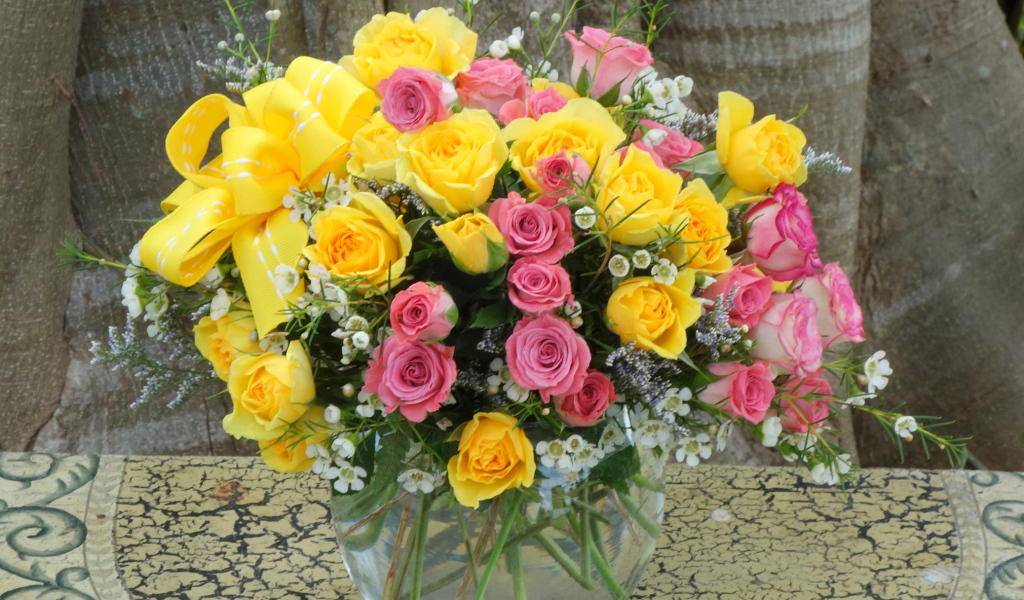 Букет желтых и розовых роз в стеклянной вазе
