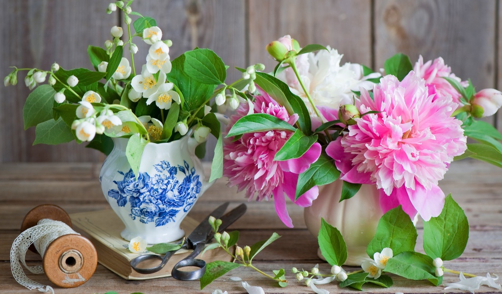 Нежные цветы жасмина и пионов в вазе на столе