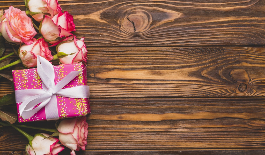 Подарочная коробка с букетом роз на деревянном фоне 