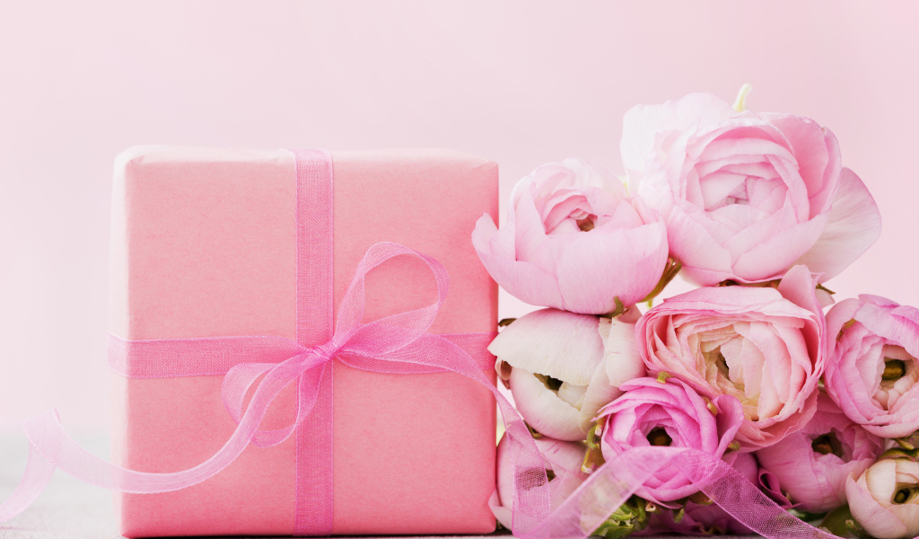 Розовый подарок с букетом розовых лютиков на розовом фоне