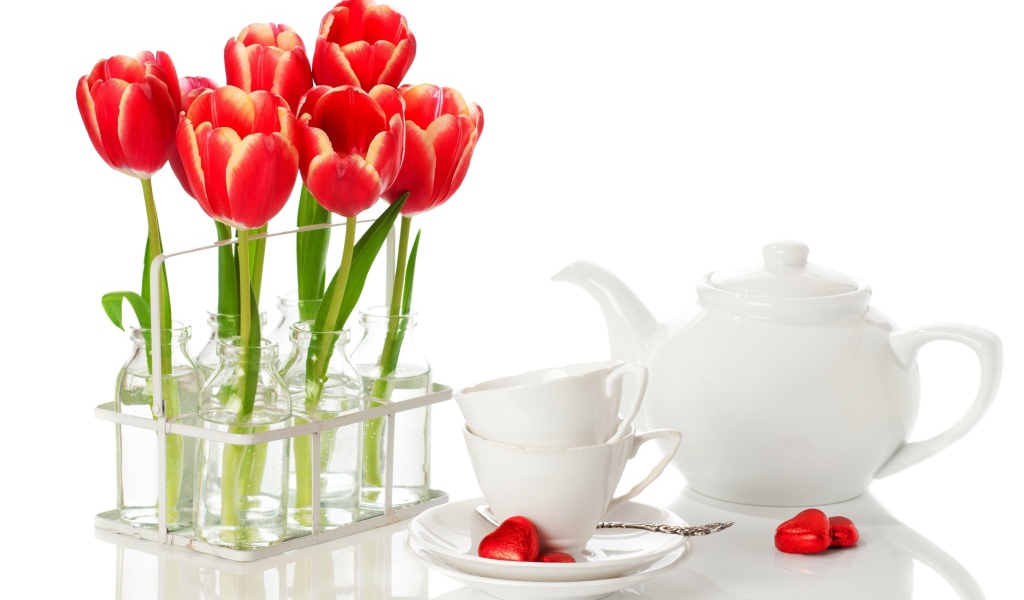 Красные тюльпаны с чайным сервизом на белом фоне