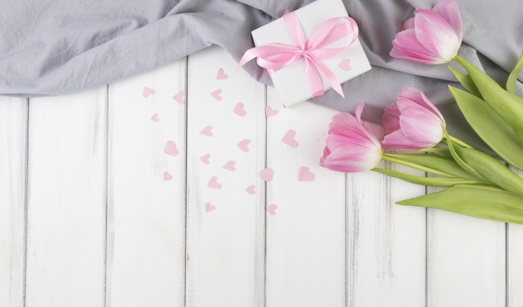 Три розовых тюльпана на столе с подарочной коробкой 