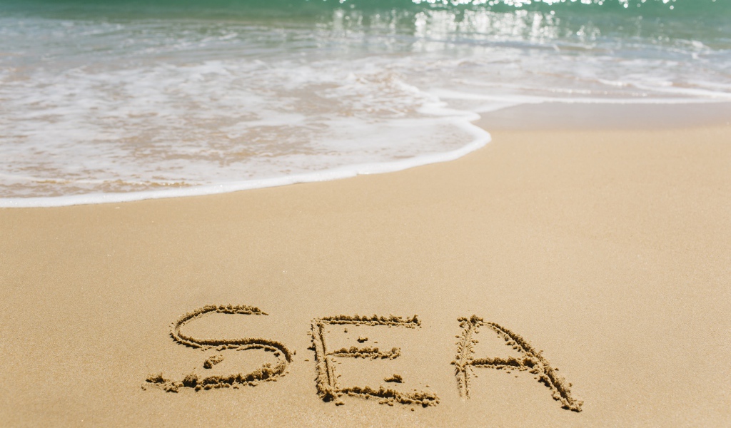 Надпись на песке у моря летом