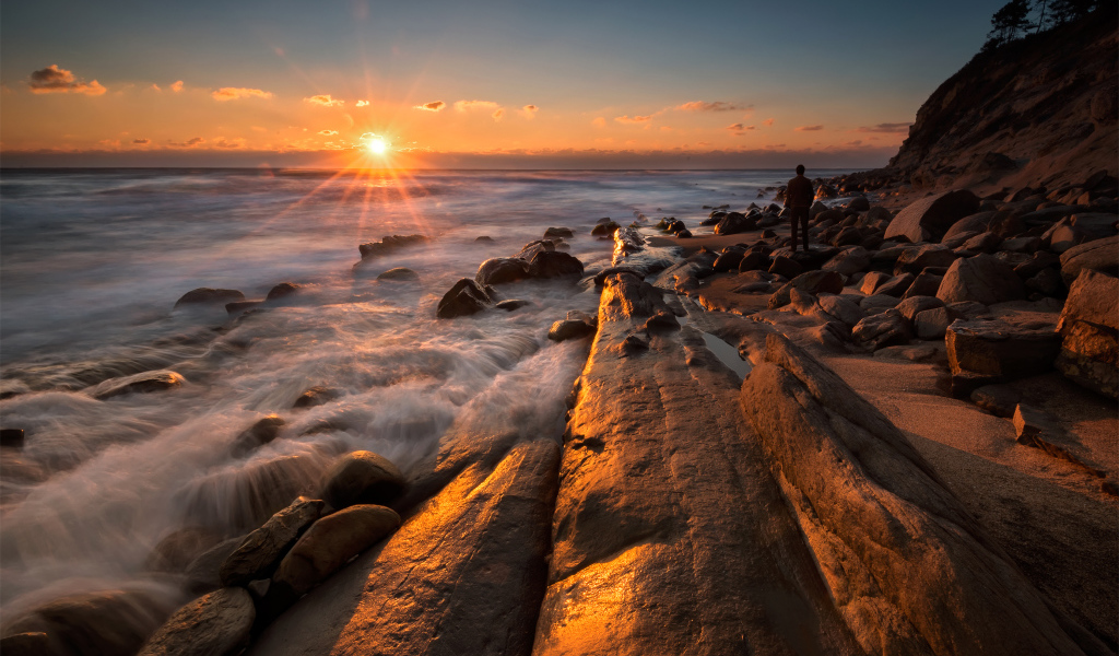Каменный берег на морском побережье на закате солнца