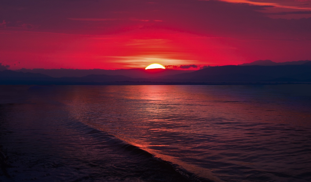 Закат красного солнца на морском горизонте 