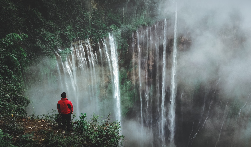Человек смотрит на водопад сверху. 