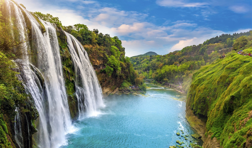 Красивый водопад стекает с утеса под голубым небом