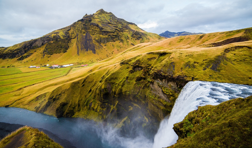 Водопад на фоне покрытых зеленью гор, Исландия