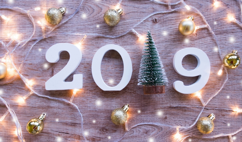 Цифры 2019 на деревянном фоне с елочными игрушками и гирляндой