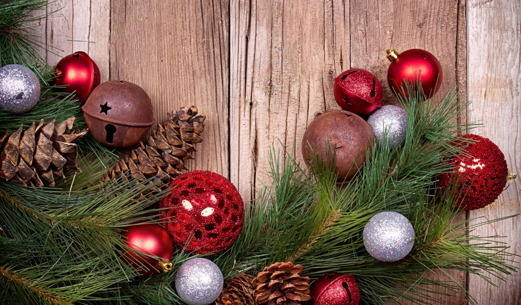 Зеленая еловая ветка с шишками и игрушками на деревянном фоне