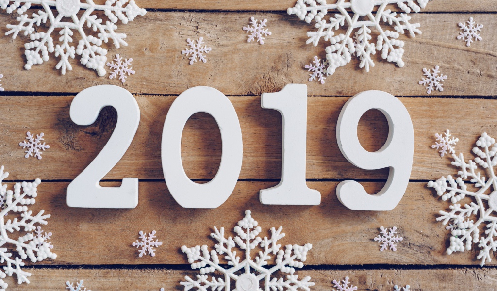 Белые цифры 2019 на деревянном столе с белыми снежинками