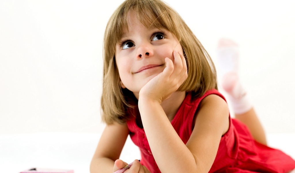 Милая девочка в красном платье рисует