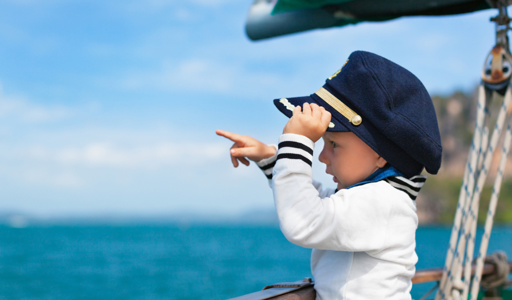 Маленький мальчик в форме капитана на корабле