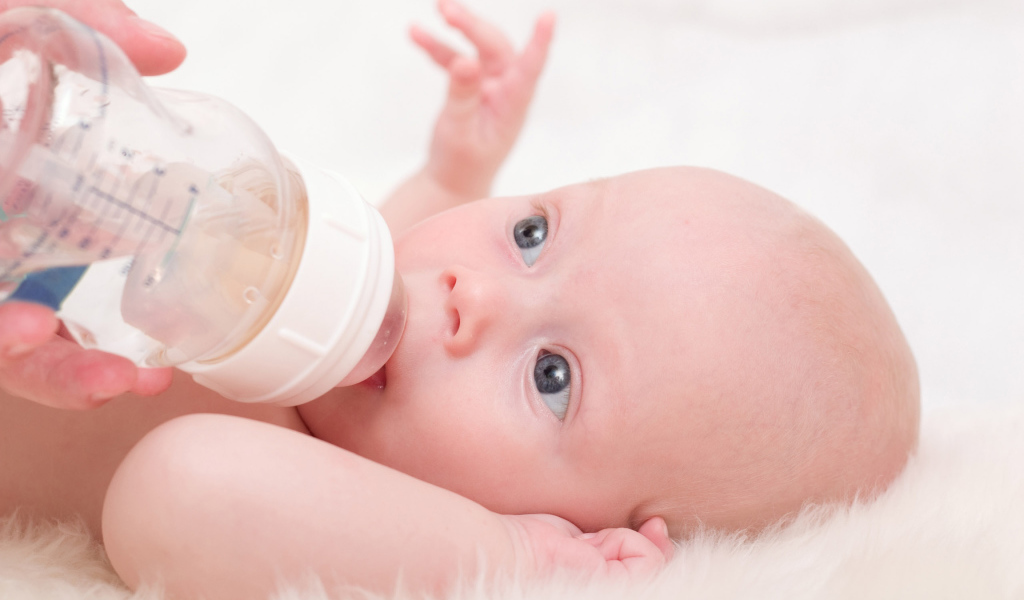 Новорожденного ребенка кормят с бутылки