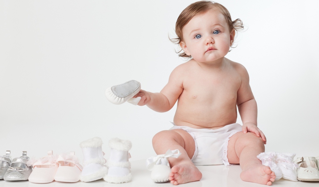 Маленький грудной ребенок с детской обувью