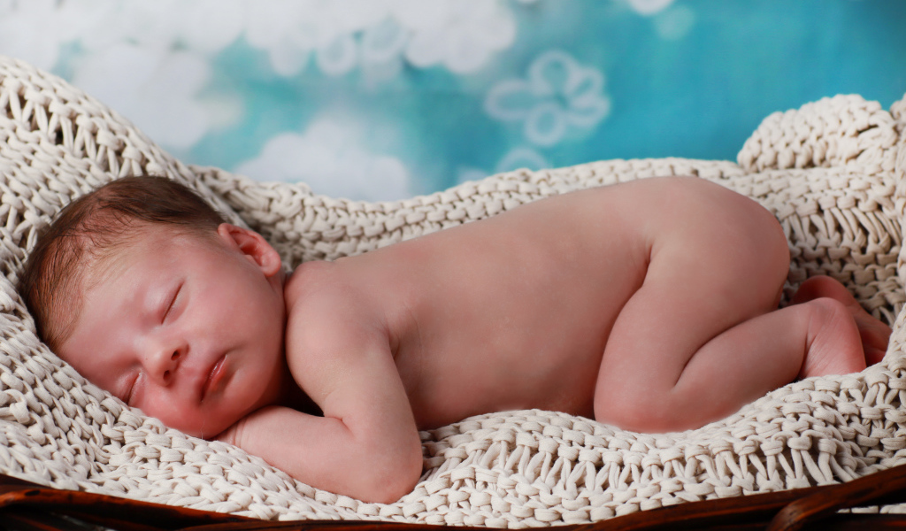 Маленький спящий грудной ребенок в колыбели