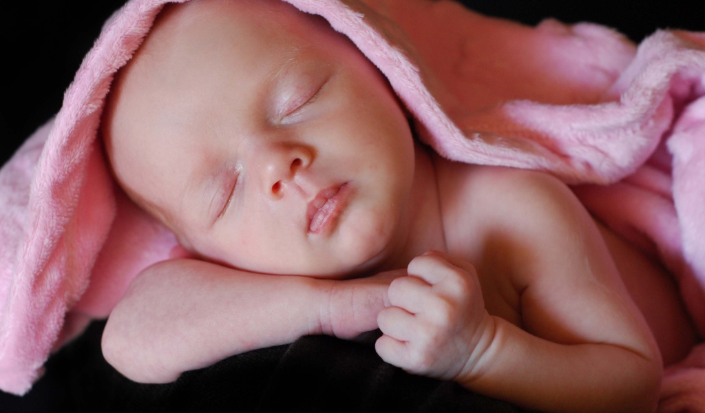 Милый спящий младенец под розовым покрывалом