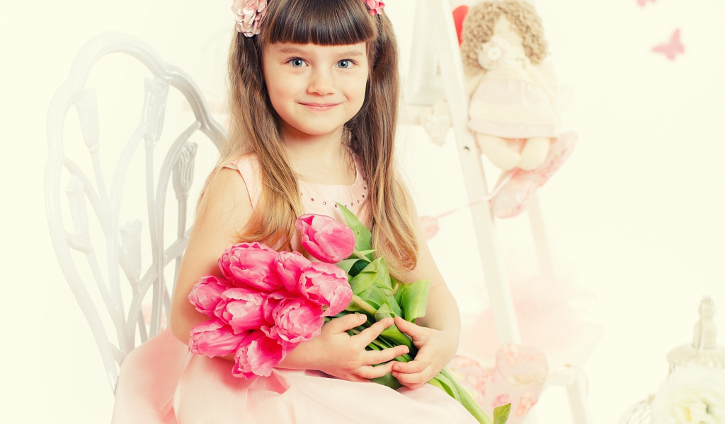 Красивая милая голубоглазая девочка с букетом розовых тюльпанов
