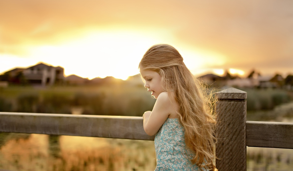 Красивая маленькая девочка на закате солнца