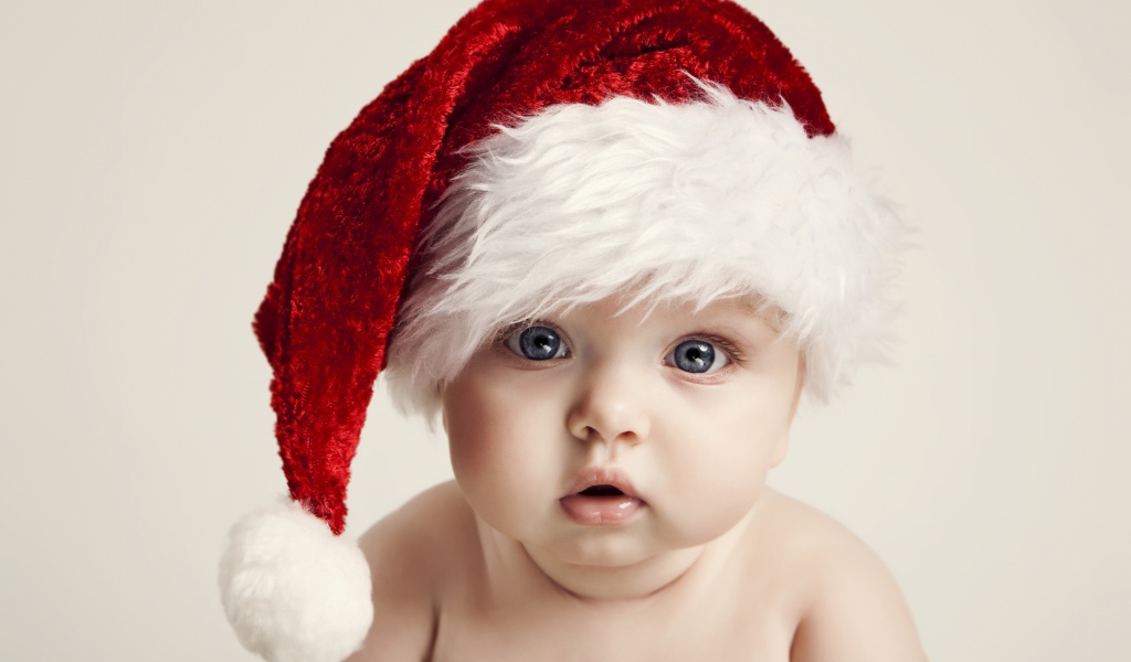 Голубоглазый малыш в красной шапке деда мороза