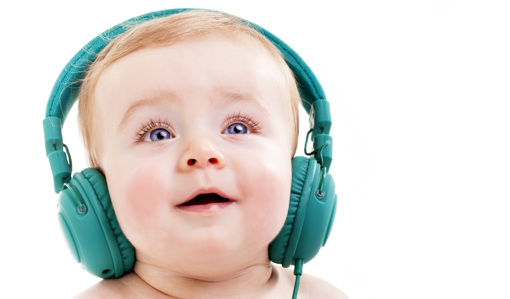 Милый младенец в больших наушниках на белом фоне