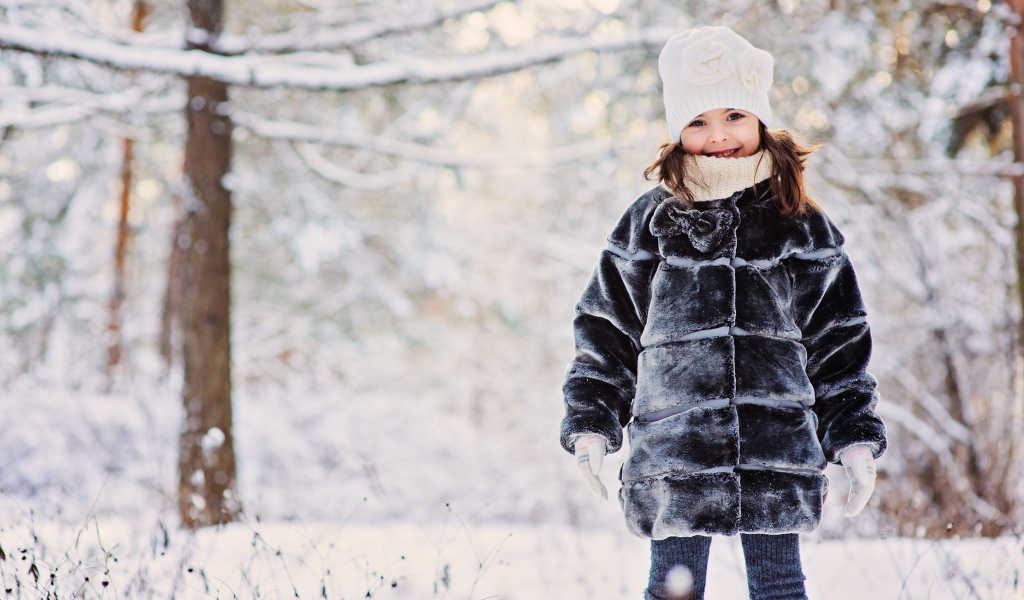 Милая маленькая девочка в шубе зимой