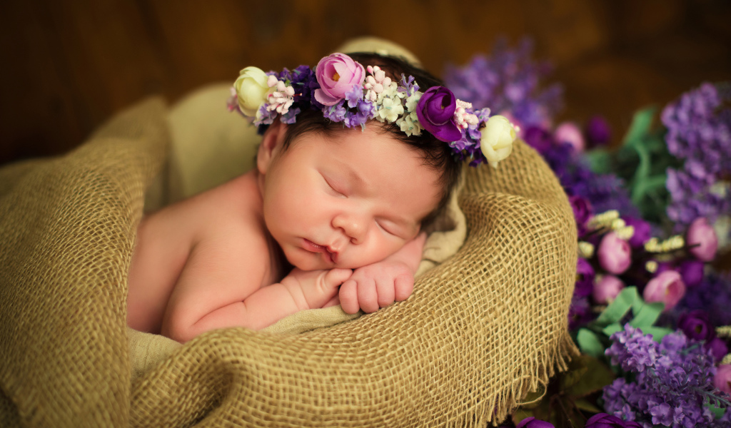 Милый спящий младенец с венком на голове