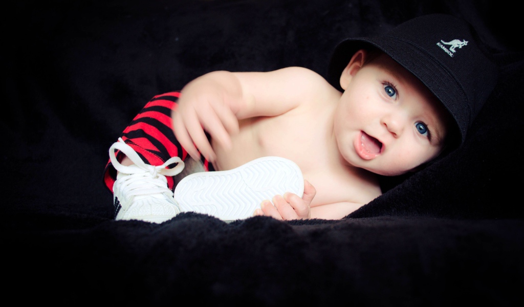 Забавный улыбающийся ребенок в черной панаме