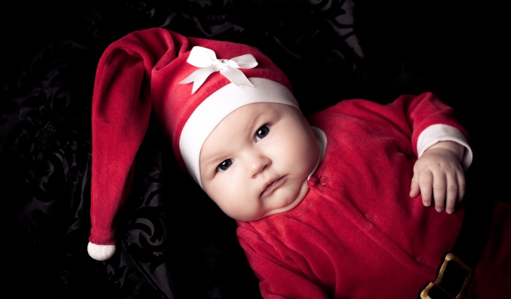 Грудной ребенок в красном новогоднем костюме