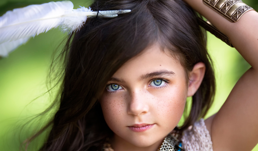 Маленькая красивая девочка с белым пером в волосах