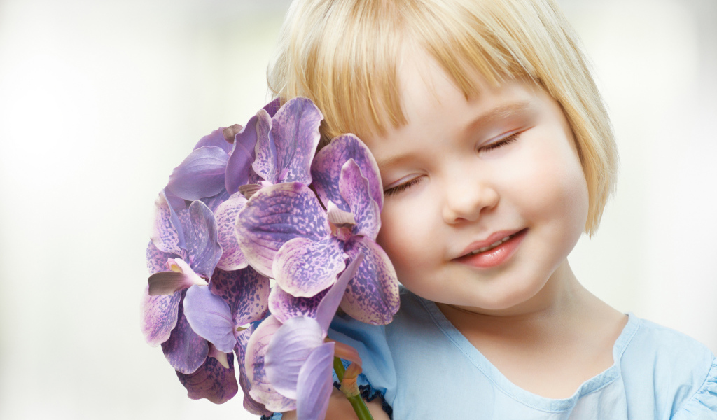 Маленькая девочка блондинка с цветами орхидеи