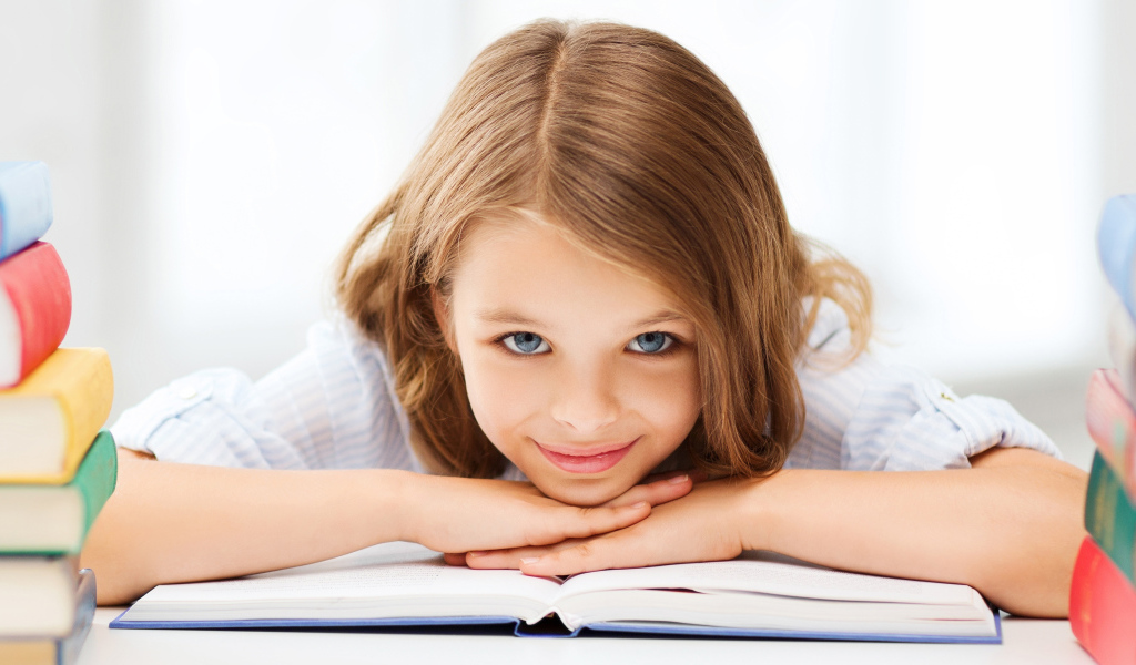 Маленькая голубоглазая девочка школьница с книгой 