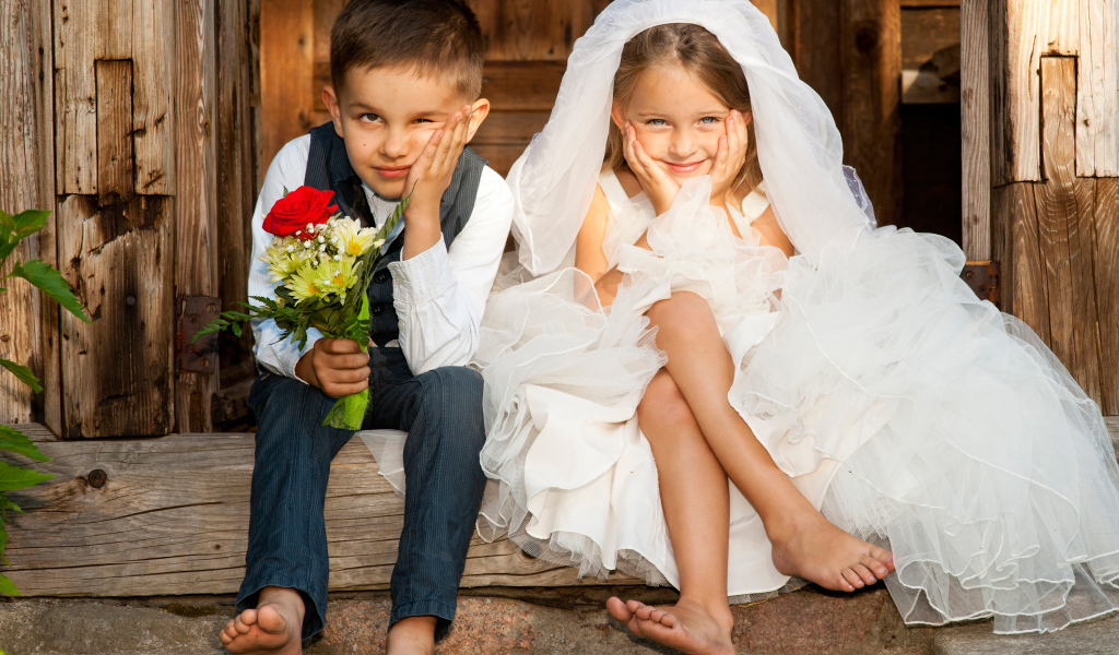 Маленькие мальчик и девочка в нарядах жениха и невесты