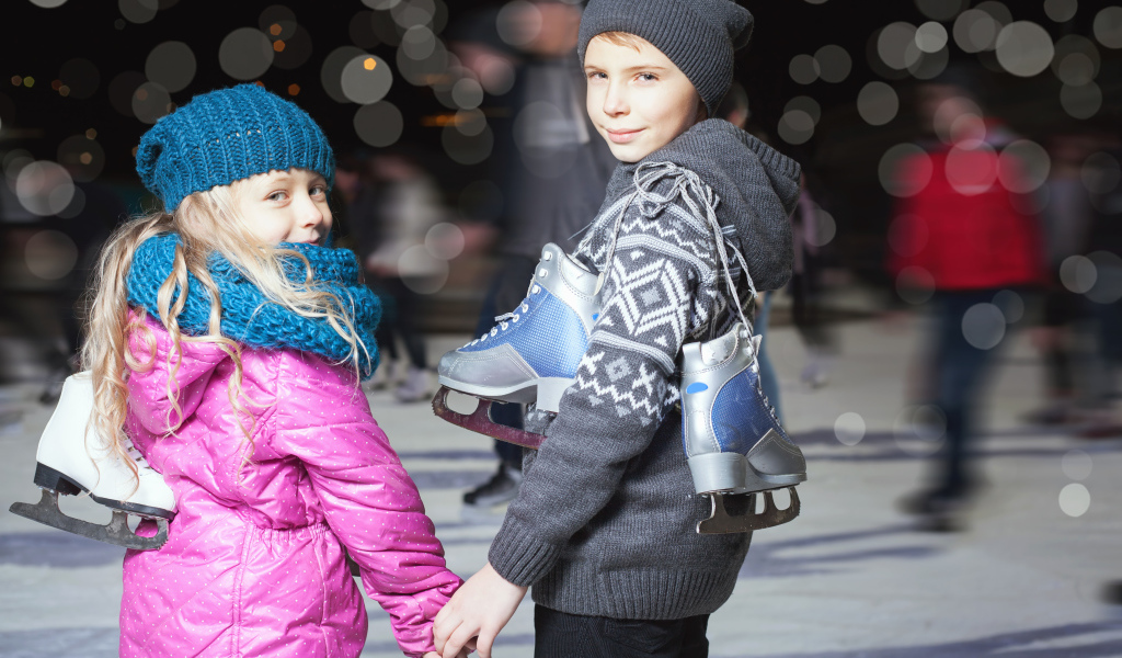 Маленькие мальчик и девочка на катке