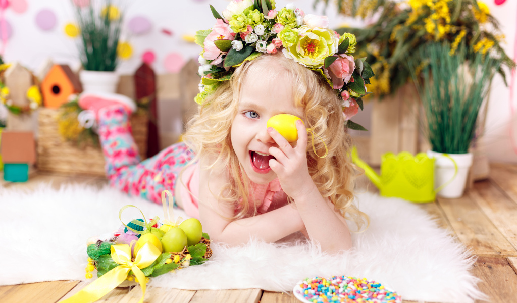 Маленькая веселая девочка с пасхальными яйцами