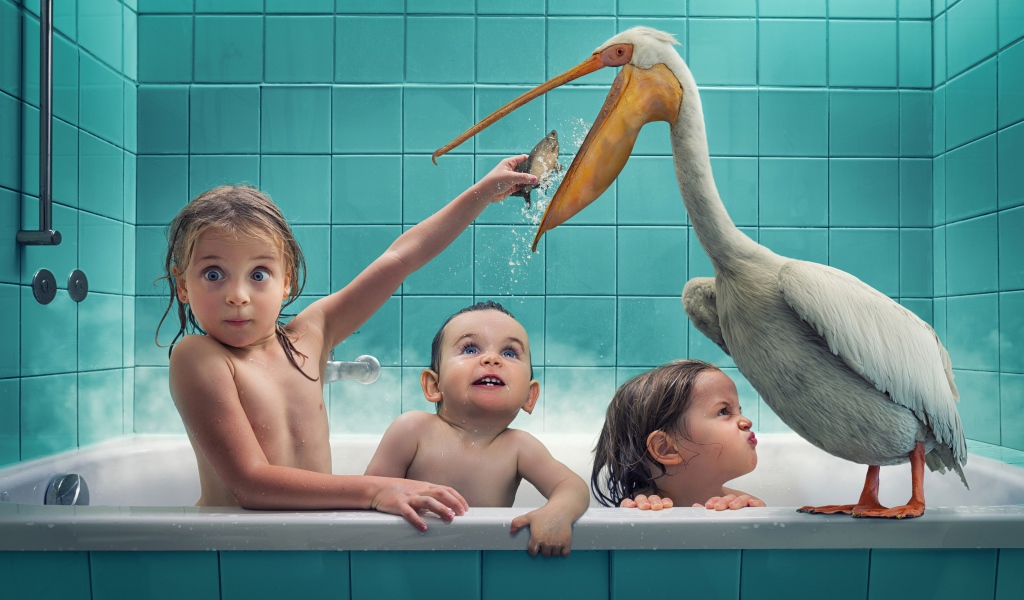 Маленькие дети сидят в ванной с пеликаном