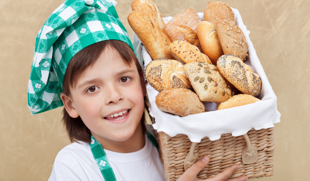 Маленькой поваренок с корзиной свежей выпечки 