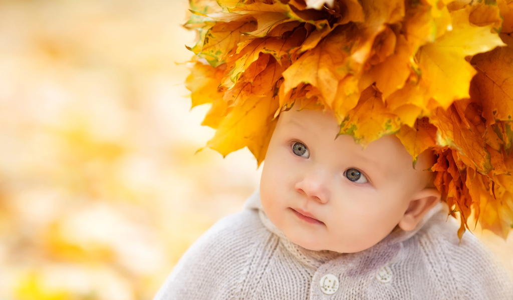 Маленький милый ребенок с венком из желтых листьев на голове 