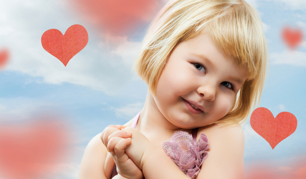 Маленькая милая девочка на фоне красных сердечек